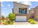 Contemporary home with a two-car garage, a second-story balcony, and manicured landscaping in the front yard at 9743 Mojave Mountain St, Las Vegas, NV 89166