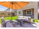 Inviting patio area with comfortable seating, an umbrella for shade, and well-maintained landscaping, perfect for relaxing outdoors at 9743 Mojave Mountain St, Las Vegas, NV 89166