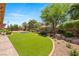An inviting backyard showcasing lush artificial grass, mature trees, and pristine landscaping at 9747 Cathedral Pines Ave, Las Vegas, NV 89149