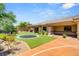 An inviting backyard featuring lush artificial grass, mature trees, a basketball court and trampoline at 9747 Cathedral Pines Ave, Las Vegas, NV 89149