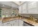 Stylish bar area with granite countertops, glass-front cabinets, and a view of the outdoor space at 9747 Cathedral Pines Ave, Las Vegas, NV 89149