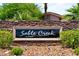 Community signage displays a wall with stone and desert landscaping at the Sable Creek entrance at 9747 Cathedral Pines Ave, Las Vegas, NV 89149