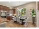 Elegant dining area with a modern chandelier, a large window, and direct access to the kitchen at 9747 Cathedral Pines Ave, Las Vegas, NV 89149