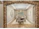 Elegant dining room features a stone archway, a decorative chandelier, and a large window for natural light at 9747 Cathedral Pines Ave, Las Vegas, NV 89149
