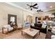 Bright living room with a decorative mirror, comfortable seating, and an open view of the kitchen at 9747 Cathedral Pines Ave, Las Vegas, NV 89149