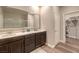 Well-lit bathroom with a double sink vanity, large mirror, and a walk-in closet at 9785 W Meranto Ave, Las Vegas, NV 89178