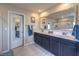 Modern bathroom featuring a double sink vanity, large mirror, and walk-in shower at 9785 W Meranto Ave, Las Vegas, NV 89178