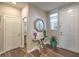 Entryway with wood floors, elegant table, decorative mirror, and a view of the downstairs powder room at 9785 W Meranto Ave, Las Vegas, NV 89178