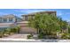 Two story home featuring a paver driveway, desert landscaping, and mature shade trees at 9785 W Meranto Ave, Las Vegas, NV 89178