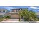 Two story home featuring a paver driveway, desert landscaping, and mature shade trees at 9785 W Meranto Ave, Las Vegas, NV 89178