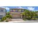 Two-story home with a well-manicured front yard, a paved driveway, and a welcoming entrance at 9785 W Meranto Ave, Las Vegas, NV 89178