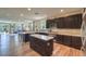 Spacious kitchen with stone countertops, stainless appliances, kitchen island, dark wood cabinets, and eat-in dining at 9785 W Meranto Ave, Las Vegas, NV 89178