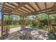 Underneath backyard pergola with string lights above a table and chairs, set in the garden area at 9785 W Meranto Ave, Las Vegas, NV 89178