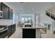 Open kitchen with granite island flowing to living area and stairs at 9844 Kings Glen St, Las Vegas, NV 89141