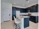 Modern kitchen with dark cabinetry, granite countertops, stainless steel appliances, and seating at the island at 9844 Kings Glen St, Las Vegas, NV 89141