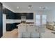 Bright kitchen features dark cabinets, granite countertops, stainless steel appliances and a view of the living room at 9844 Kings Glen St, Las Vegas, NV 89141