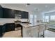 Modern kitchen featuring black cabinets, stainless steel appliances, and a granite island with seating at 9844 Kings Glen St, Las Vegas, NV 89141
