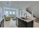 Open concept kitchen with granite island flowing into the living area and stairs to the side at 9844 Kings Glen St, Las Vegas, NV 89141
