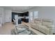 Spacious living room with a plush sofa and view into the modern kitchen featuring a center island at 9844 Kings Glen St, Las Vegas, NV 89141