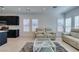 Bright, open-concept living room with neutral furnishings, modern decor, and ample natural light with kitchen view at 9844 Kings Glen St, Las Vegas, NV 89141