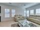 Cozy living room featuring comfortable seating, a stylish glass table, and lots of natural light at 9844 Kings Glen St, Las Vegas, NV 89141