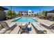 Community pool with lounge chairs, mature trees, and well-maintained landscaping surrounded by townhomes at 9844 Kings Glen St, Las Vegas, NV 89141