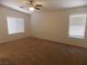Bright bedroom featuring neutral carpet, two windows, and a ceiling fan at 1018 Sun Poppy Ave, Las Vegas, NV 89123