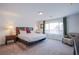 Bright bedroom featuring a king bed, sitting chair, and lots of natural light from a large window at 10435 Rose Palisade St, Las Vegas, NV 89141