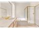 Updated bathroom featuring white cabinets, jacuzzi tub, and glass shower at 10548 Findlay Ave, Las Vegas, NV 89134