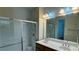 Bathroom featuring double sinks, large mirror with Hollywood lighting, and a glass enclosed shower at 11404 Belmont Lake Dr # 103, Las Vegas, NV 89135