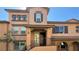 Inviting two-story home with neutral toned stucco, a covered entryway, and wrought iron stair railings at 11404 Belmont Lake Dr # 103, Las Vegas, NV 89135