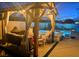 Illuminated backyard featuring a gazebo, jacuzzi, and a serene pool providing a luxurious outdoor retreat at 129 Barton Bay Ave, North Las Vegas, NV 89031