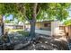 Large backyard with mature tree, covered patio, lawn, garden bed and partial fence, offering a relaxing space at 1904 Fontenelle St, Las Vegas, NV 89102