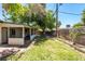 Backyard featuring a covered patio, mature trees, a brick wall, and a lawn at 1904 Fontenelle St, Las Vegas, NV 89102