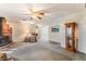 Open living room featuring a brick fireplace, plush carpeting, and a ceiling fan at 1904 Fontenelle St, Las Vegas, NV 89102