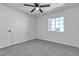 Bright bedroom boasts a ceiling fan, white walls, a large window, and neutral carpet at 220 Mission Catalina Ln # 208, Las Vegas, NV 89107