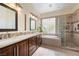 Luxurious bathroom with double sinks, a soaking tub, and a separate glass-enclosed shower at 2279 Pacini Ct, Henderson, NV 89052