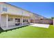 Wide backyard featuring a covered patio with artificial grass and brick walls for privacy at 262 Calvino Ave, Las Vegas, NV 89183