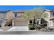 Two-story tan home featuring a two-car garage and desert landscaping at 262 Calvino Ave, Las Vegas, NV 89183
