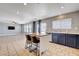 Open kitchen with stainless appliances, island with stools, and access to the living room at 262 Calvino Ave, Las Vegas, NV 89183
