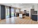 Open kitchen with stainless appliances, granite counters, and tile flooring leading to backyard at 262 Calvino Ave, Las Vegas, NV 89183