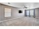 Spacious living room with plush carpet, bright windows, modern ceiling fan, and mounted television at 262 Calvino Ave, Las Vegas, NV 89183