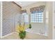 Bright bathroom features a walk-in shower, jetted tub, and a window with glass blocks for natural light at 2899 Brook Trout Ct, Henderson, NV 89052