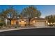 Inviting home exterior with a three car garage, mature trees, and manicured landscaping at 2899 Brook Trout Ct, Henderson, NV 89052
