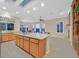 Open kitchen with tile floors, island cooktop, and a dining area with large windows at 2899 Brook Trout Ct, Henderson, NV 89052