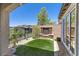 A backyard featuring a small patch of artificial grass, a modern fireplace and view fencing at 3 Vicolo Sebino, Henderson, NV 89011