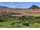 Scenic view of the lush green golf course nestled against a desert mountain backdrop at 3 Vicolo Sebino, Henderson, NV 89011