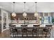 Stunning kitchen island featuring white countertop, a sink, dark cabinets, and four comfortable chairs at 3 Vicolo Sebino, Henderson, NV 89011