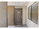 Neutral-toned condo entrance with a gray door, security peephole, and storm window at 3151 Soaring Gulls Dr # 1066, Las Vegas, NV 89128