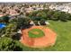 Aerial view of a well-kept baseball field within a community park, surrounded by lush greenery and residential areas at 317 Brent Ct, Henderson, NV 89074